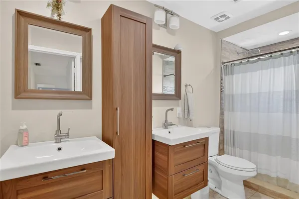 a bathroom with a sink toilet a mirror and shower
