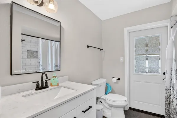 a bathroom with a sink toilet and mirror