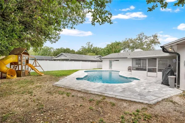 a view of a house with a yard and a large tree