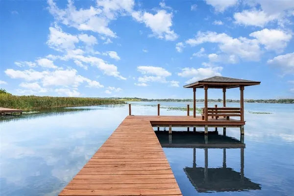 a balcony with wooden benches and lake view