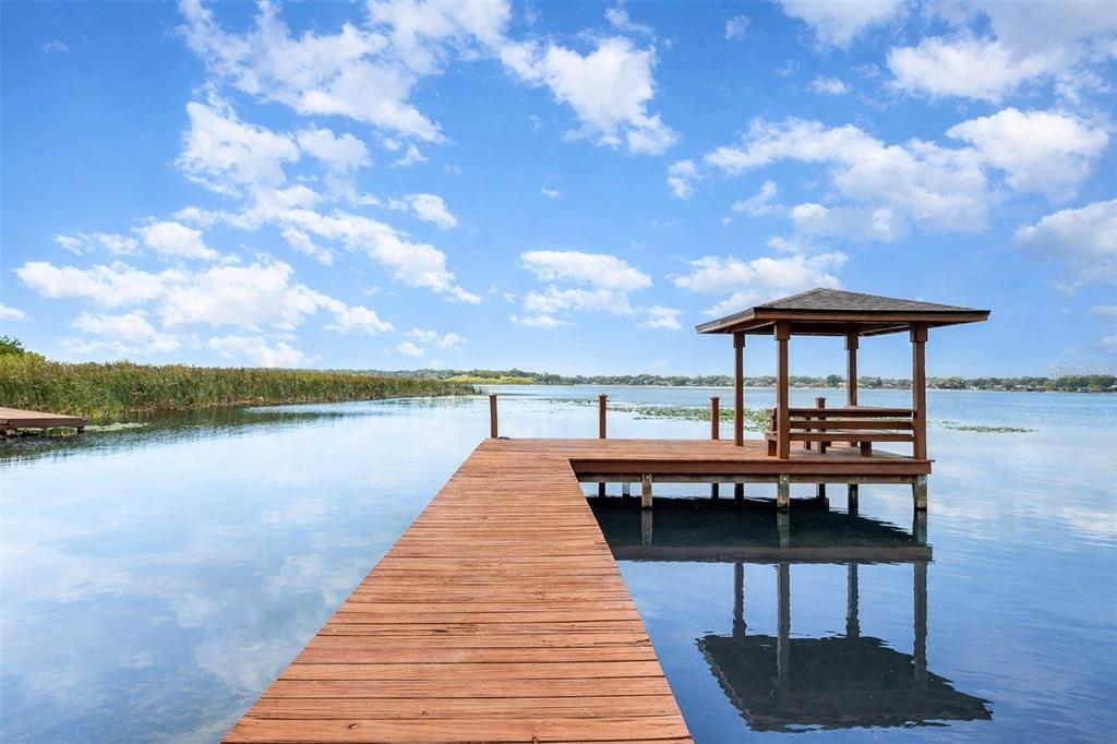 4222 Old Dominion Road Orlando, FL 32812 - Photo 33 of 49 a balcony with wooden benches and lake view
