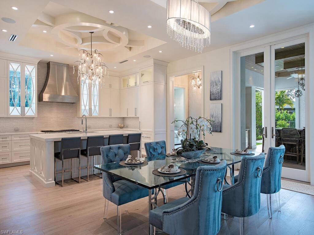 714 Killdeer Place Naples, FL 34108 - Photo 11 of 34 a kitchen with a dining table cabinets appliances and a counter top space
