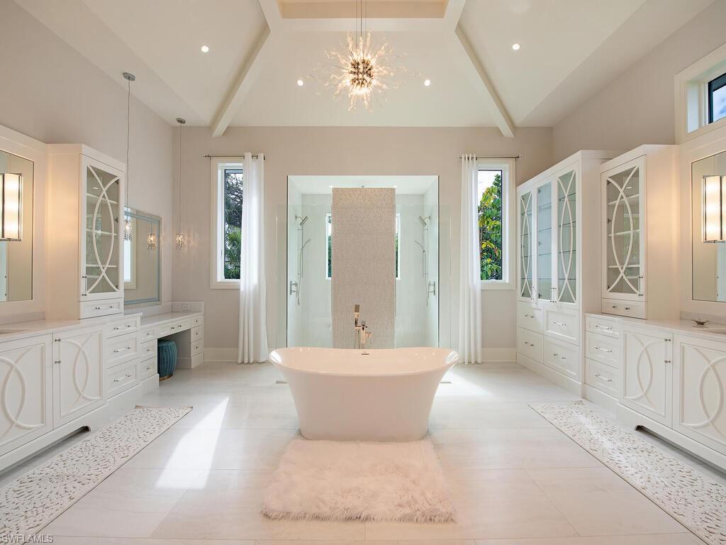 714 Killdeer Place Naples, FL 34108 - Photo 21 of 34 a spacious bathroom with a double vanity sink a mirror and a bathtub