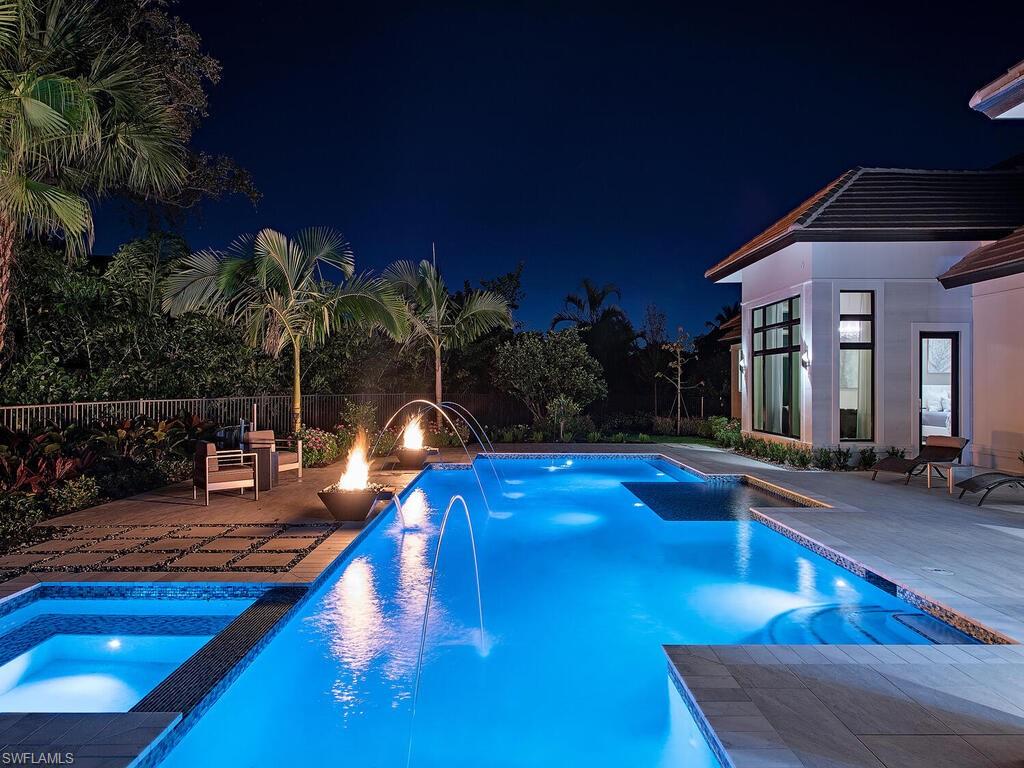 714 Killdeer Place Naples, FL 34108 - Photo 28 of 34 a view of a house with swimming pool lawn chairs and a yard