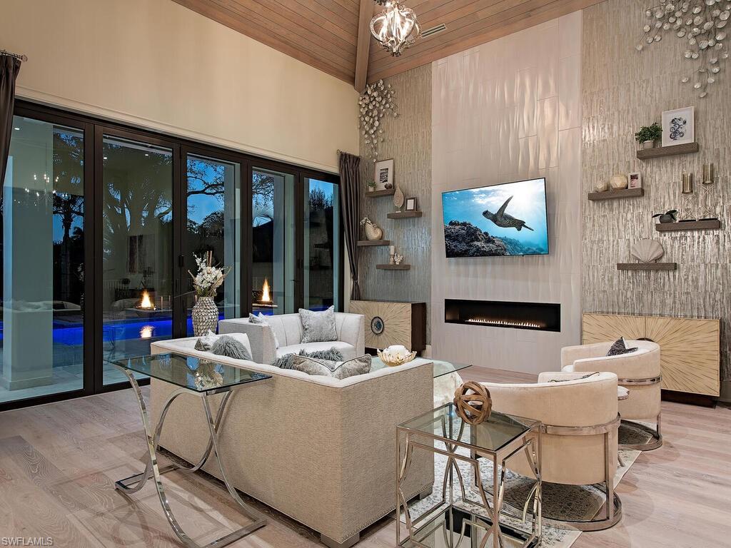 714 Killdeer Place Naples, FL 34108 - Photo 31 of 34 a living room with fireplace furniture and a flat screen tv