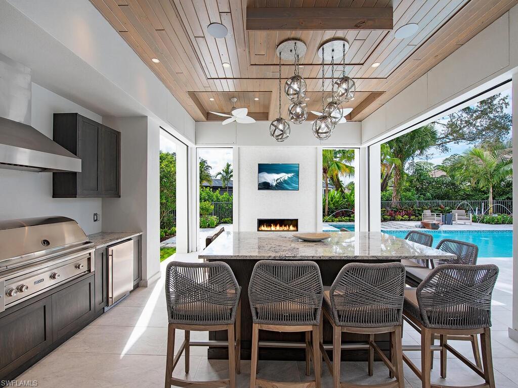 714 Killdeer Place Naples, FL 34108 - Photo 8 of 34 a view of a dining room with furniture large windows and a chandelier