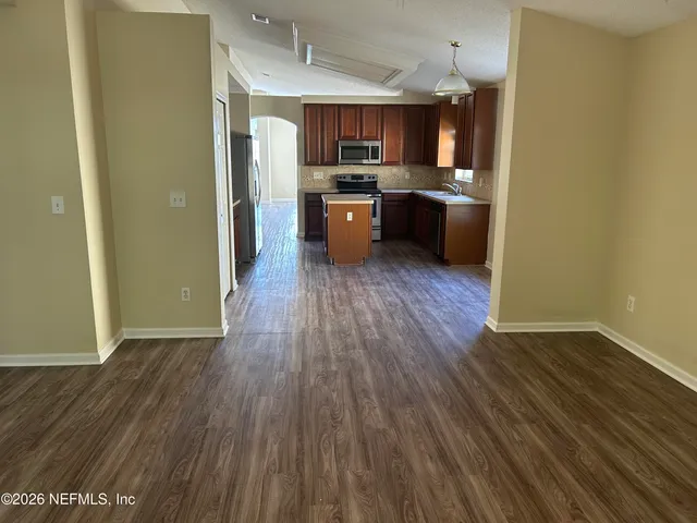 a kitchen with wooden floors and stainless steel appliances
