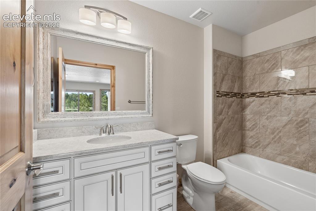 10840 Vollmer Road Colorado Springs, CO 80908 - Photo 34 of 49 a bathroom with a sink toilet vanity and shower