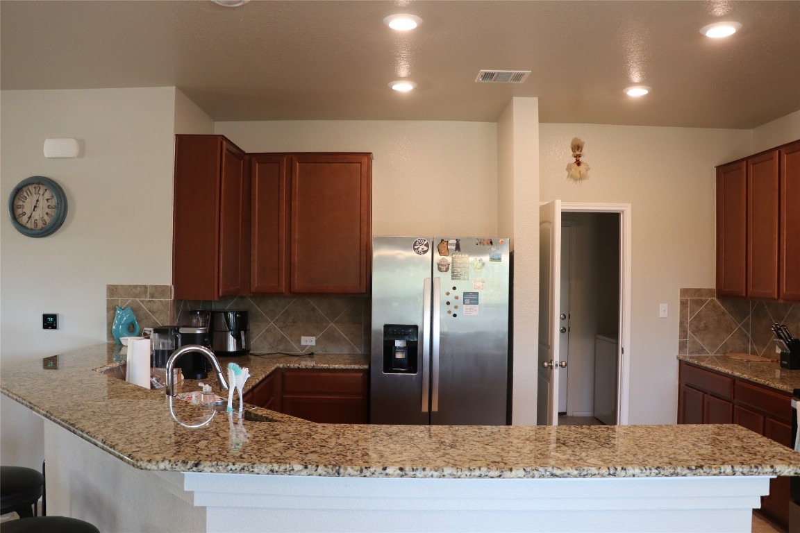 321 Parrot Tulip View Pflugerville, TX 78660 - Photo 13 of 33 a kitchen with granite countertop a refrigerator a stove and a sink