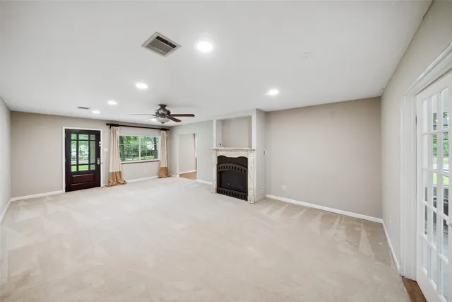 an empty room with windows and a ceiling fan