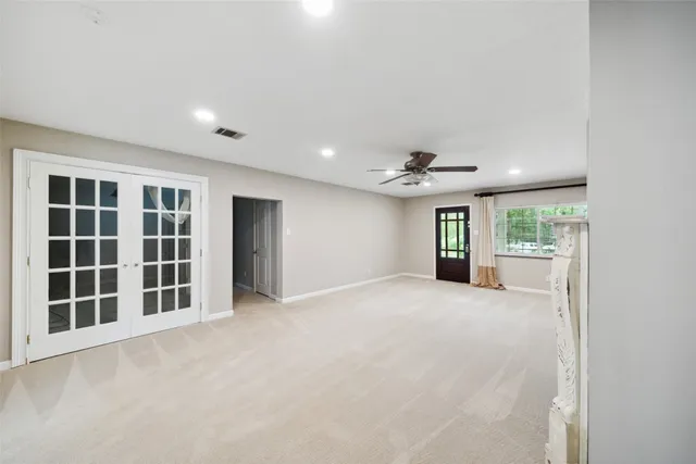 a view of an empty room with a window and kitchen view