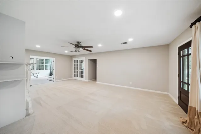 en empty room with windows and ceiling fan
