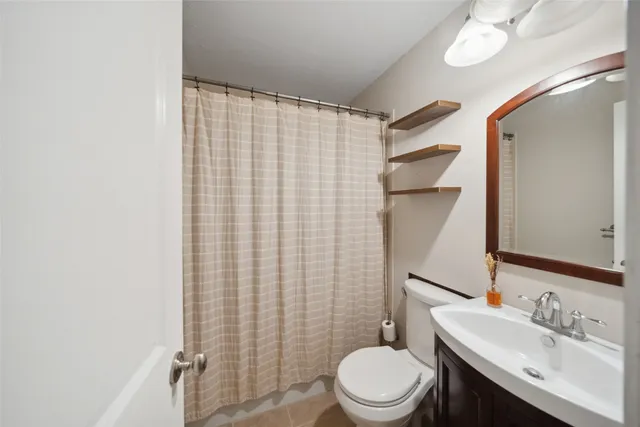 a bathroom with a sink a toilet and shower curtain