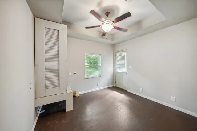 an empty room with a window and ceiling fan