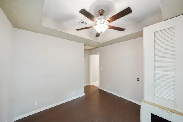 an empty room with a window and a ceiling fan