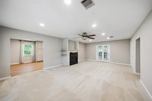 an empty room with windows and cabinet