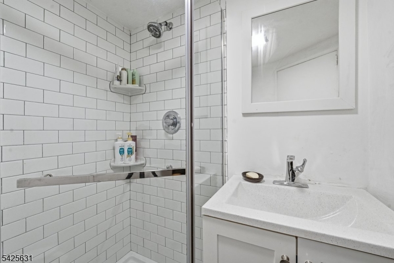 60 Westervelt Place Lodi, NJ 07644 - Photo 34 of 48 a bathroom with a sink a toilet and shower