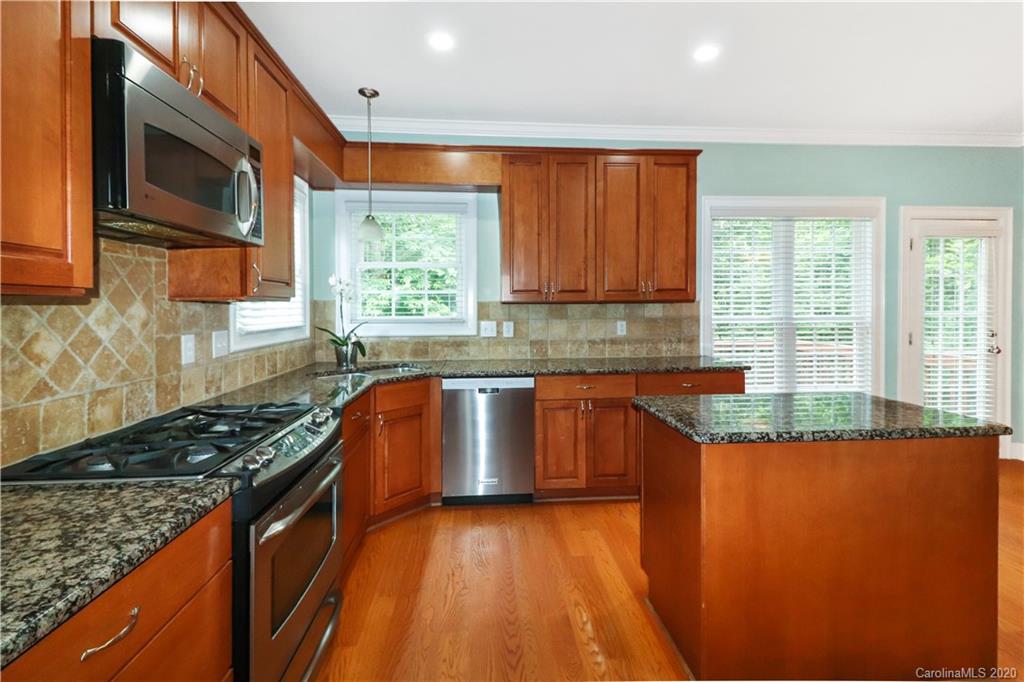 11156 Turtle Bay Court Tega Cay, SC 29708 - Photo 8 of 22 a kitchen with granite countertop stainless steel appliances a stove sink and microwave