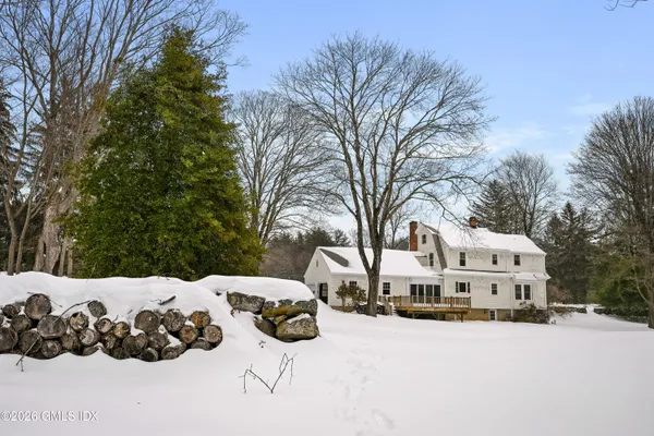 a view of white house with a yard covered in snow