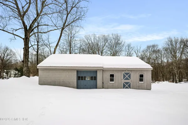 a front view of a house with a yard covered in snow