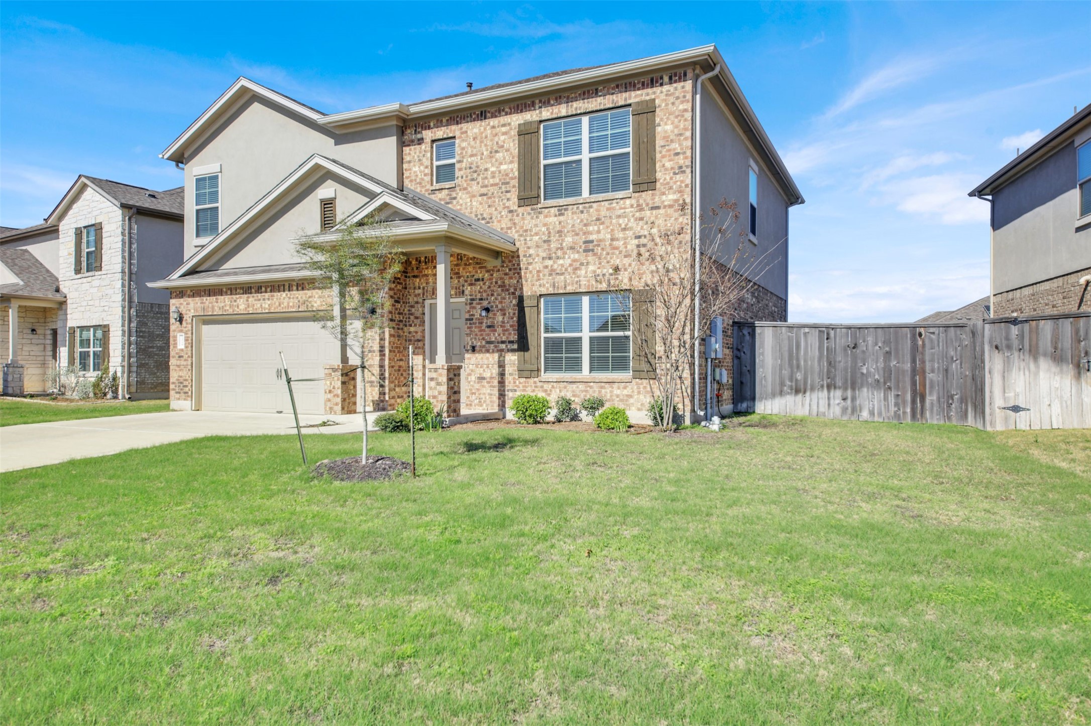 13716 Sugar Bush Path Manor, TX 78653 - Photo 3 of 37 View of front of house with concrete driveway and brick siding