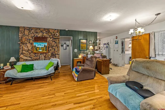 a utility room with stainless steel appliances granite countertop a refrigerator a stove a sink dishwasher and white cabinets next to a window