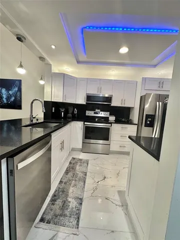 a kitchen with stainless steel appliances granite countertop a refrigerator sink and stove