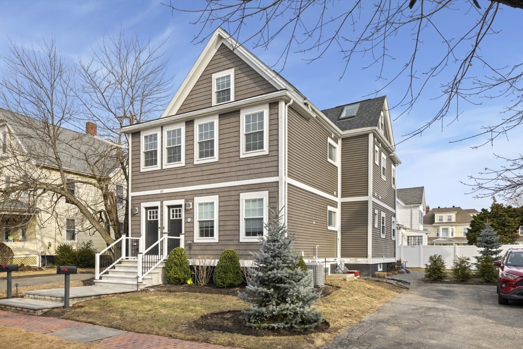 87 Otis Street, Unit 2 Medford, MA 02155 - Photo 1 of 42 a front view of a house with a yard