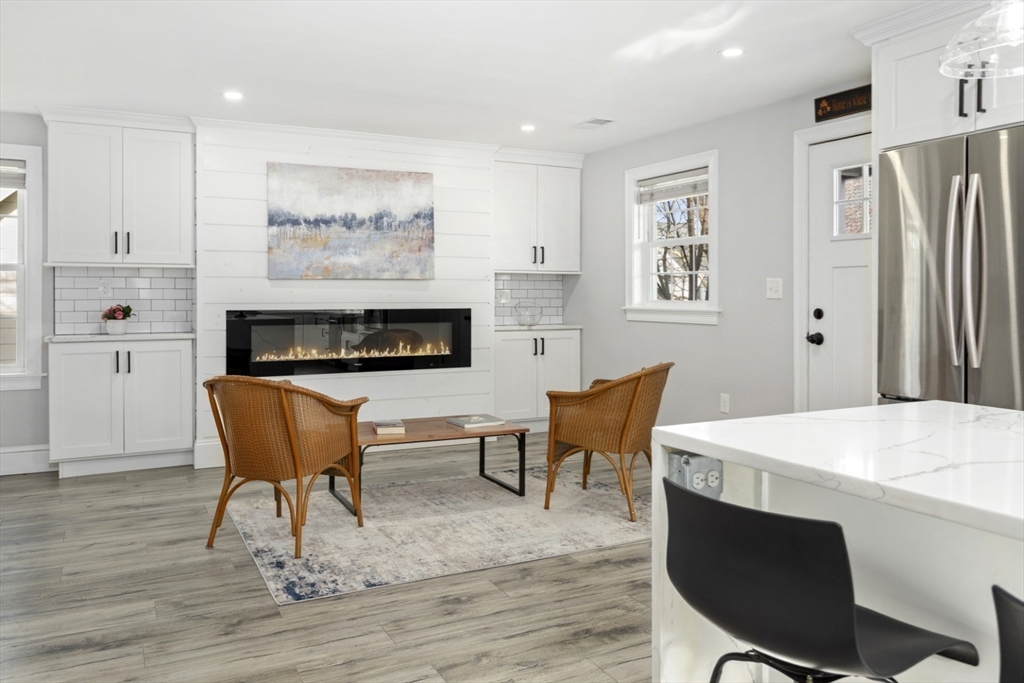 87 Otis Street, Unit 2 Medford, MA 02155 - Photo 17 of 42 a living room with furniture a flat screen tv and a table