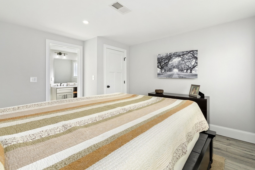 87 Otis Street, Unit 2 Medford, MA 02155 - Photo 21 of 42 a bedroom with bed and paintings on the wall