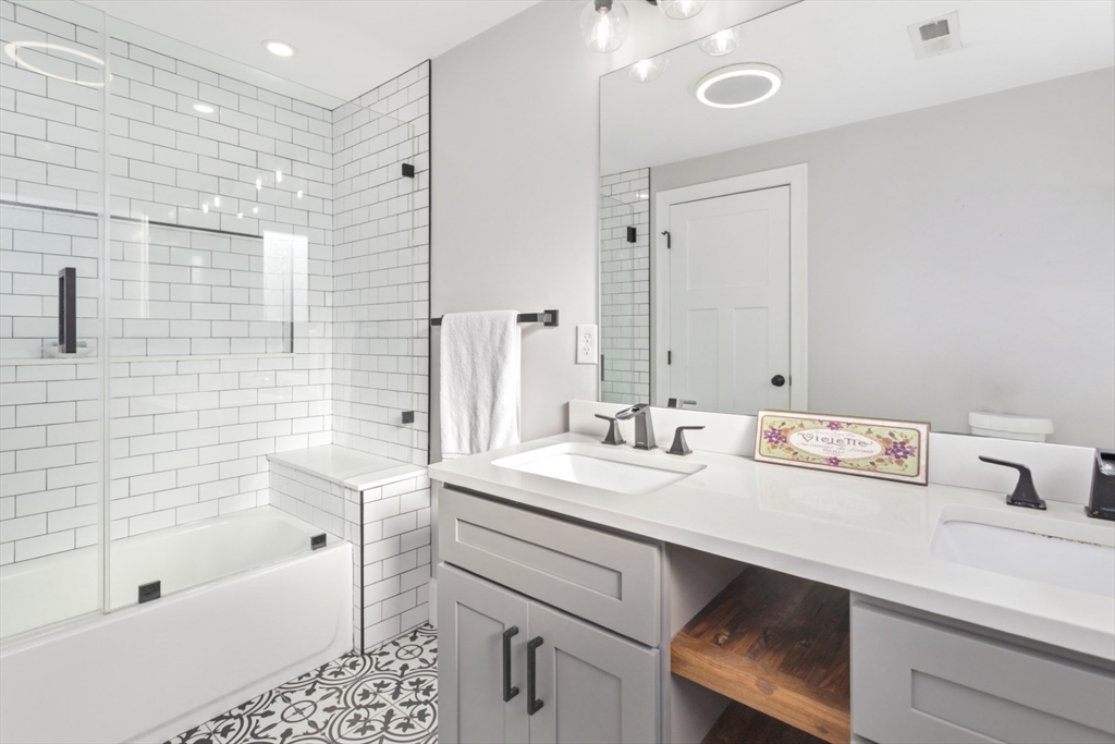 87 Otis Street, Unit 2 Medford, MA 02155 - Photo 23 of 42 a bathroom with a sink a large mirror and shower