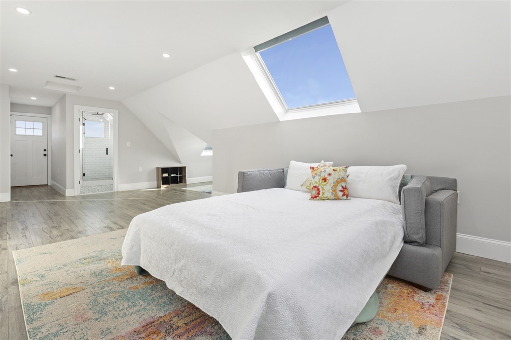 87 Otis Street, Unit 2 Medford, MA 02155 - Photo 32 of 42 a spacious bedroom with a bed and a couch
