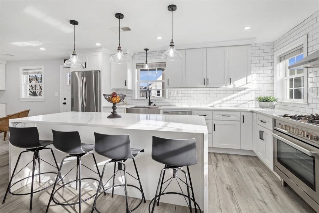 87 Otis Street, Unit 2 Medford, MA 02155 - Photo 9 of 42 a kitchen with a sink and chairs