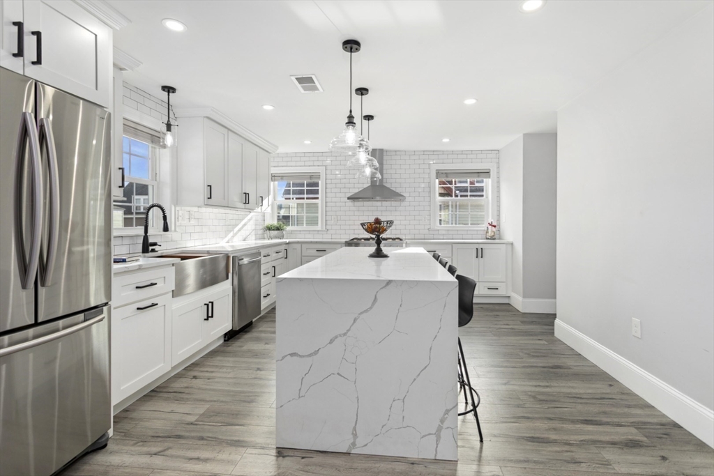 87 Otis Street, Unit 2 Medford, MA 02155 - Photo 10 of 42 a kitchen with a sink stainless steel appliances and white cabinets