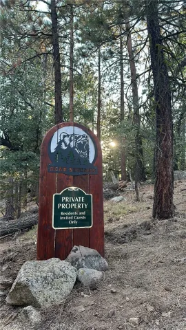 a sign that is sitting in front of a tree