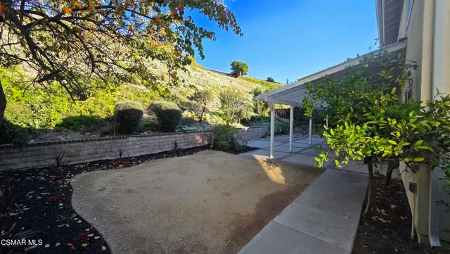 a view of a patio with table and chairs and a large tree