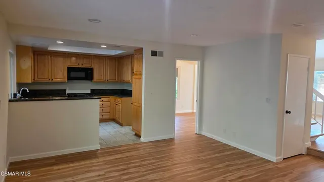 a kitchen with granite countertop a refrigerator and a stove top oven