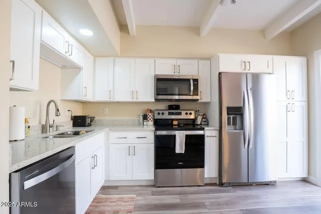 a kitchen with stainless steel appliances a refrigerator stove and sink
