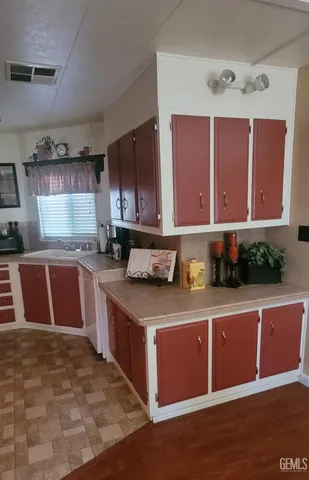 a kitchen with stainless steel appliances granite countertop a stove a sink dishwasher and a microwave oven with large wooden cabinets