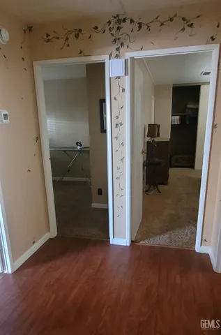 an empty room with wooden floor and a bathroom