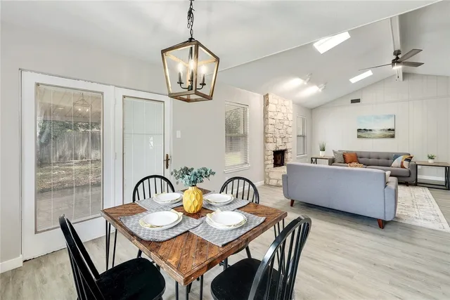 a dining room with furniture a chandelier and wooden floor