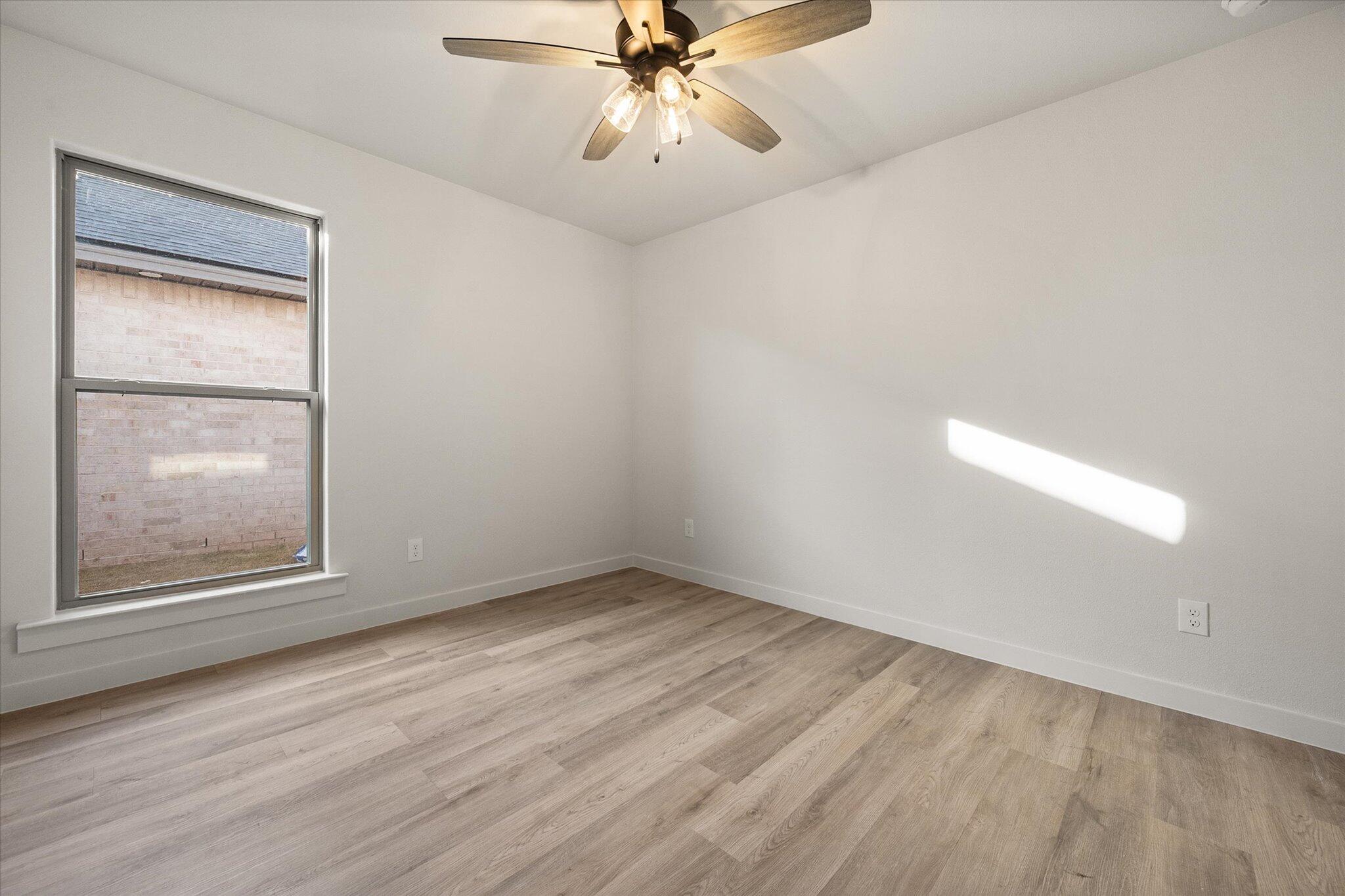 3022 138th Place Lubbock, TX 79423 - Photo 16 of 20 an empty room with a window and a fan