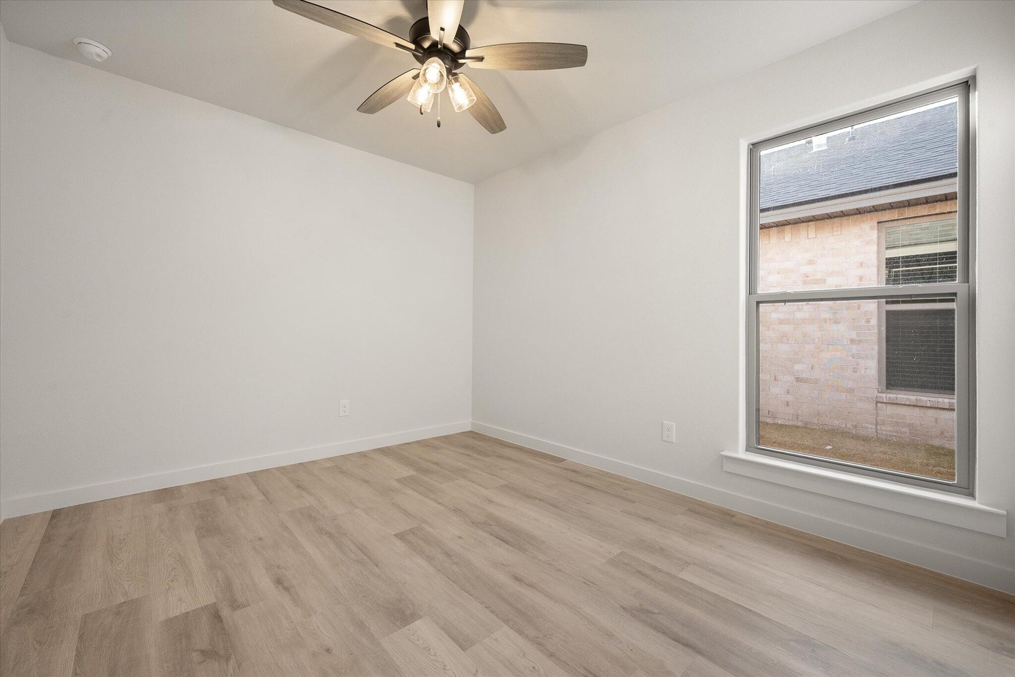 3022 138th Place Lubbock, TX 79423 - Photo 17 of 20 an empty room with a window and a fan