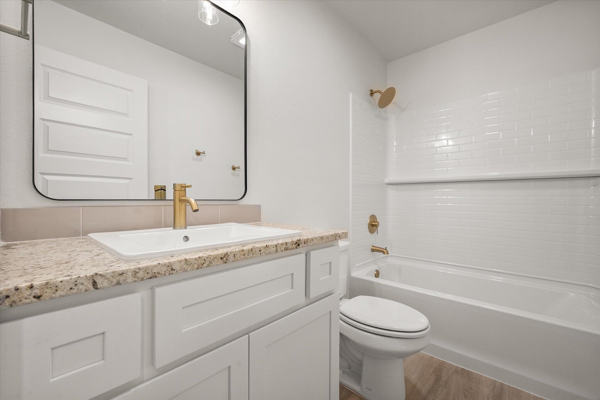 3022 138th Place Lubbock, TX 79423 - Photo 18 of 20 a bathroom with a granite countertop sink toilet and shower
