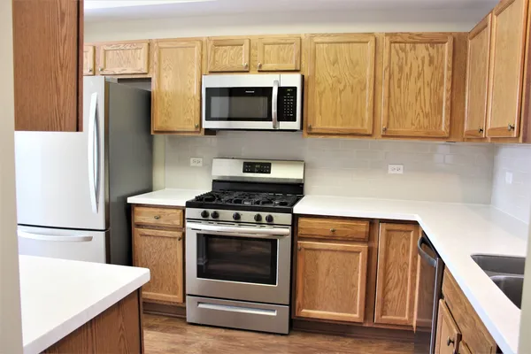 a metallic refrigerator freezer sitting in a kitchen