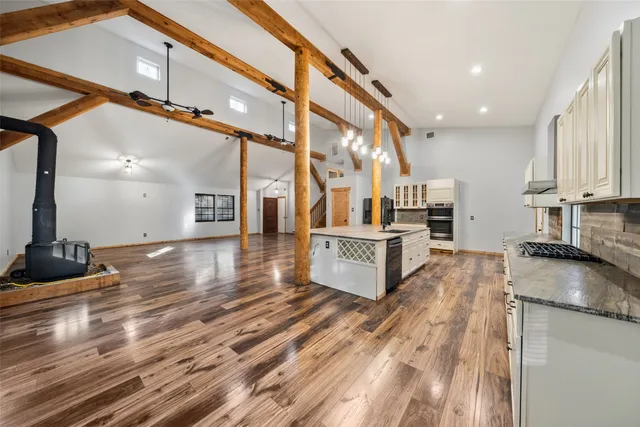 a large kitchen with stainless steel appliances kitchen island granite countertop a large counter top and a stove