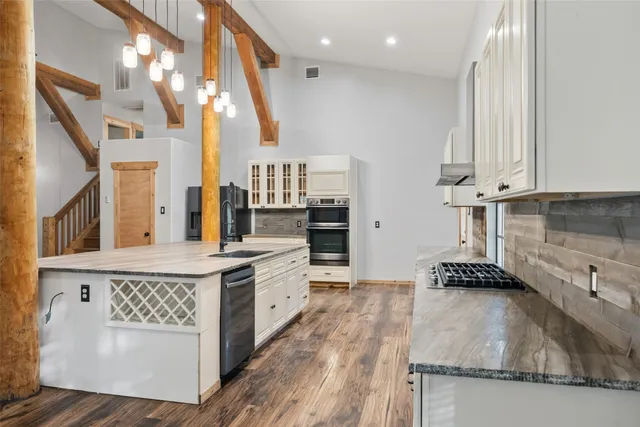 a kitchen with stainless steel appliances granite countertop a stove a sink and a microwave