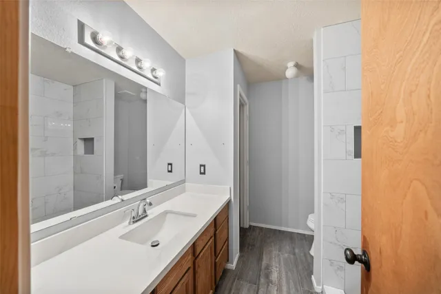 a bathroom with a sink a toilet and shower