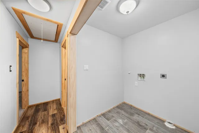 a view of empty room with wooden floor and window