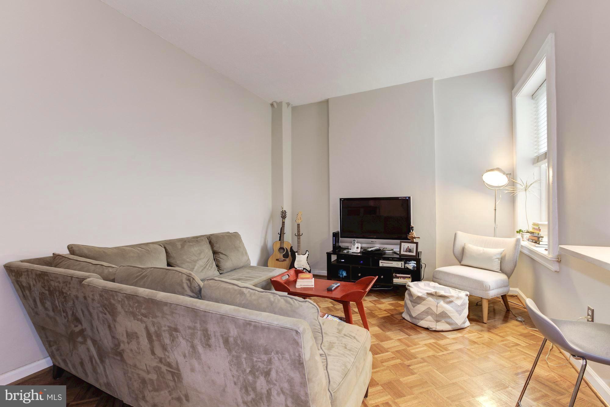 1851 Columbia Road Northwest, Unit 305 Washington, DC 20009 - Photo 2 of 28 a living room with furniture and a flat screen tv
